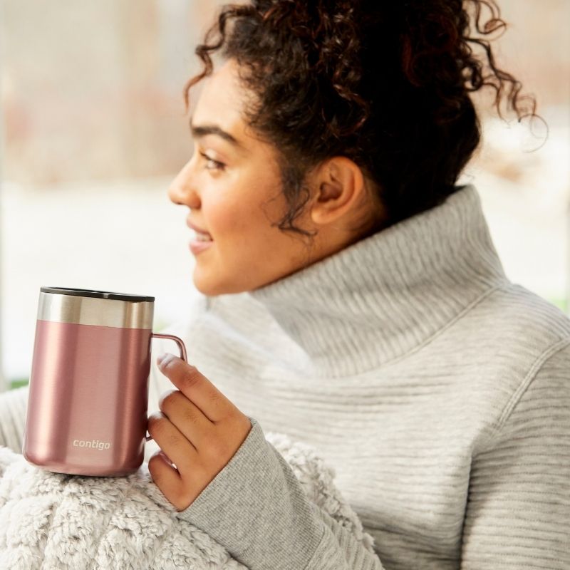Contigo Streeterville stainless steel 414ml mug with a handle in Pine Berry - showing woman with a mug in her hand. 