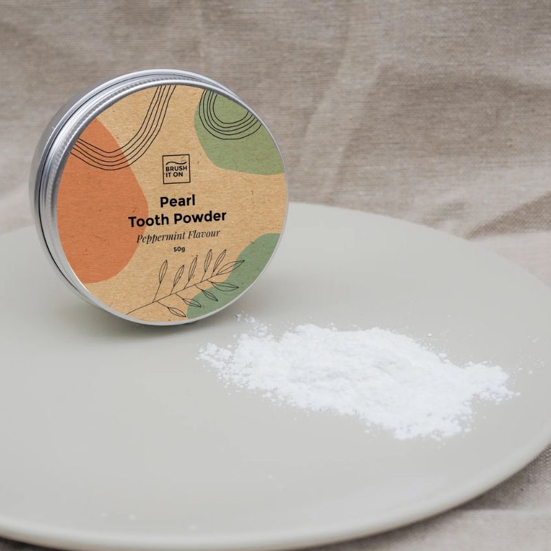 Brush It On - Pearl tooth powder - showing tin and powder next to it.