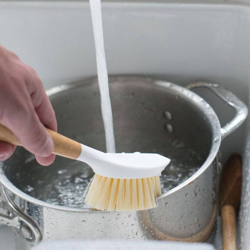 Full Circle Be Good Dish Brush in white - shown in use cleaning a pot.