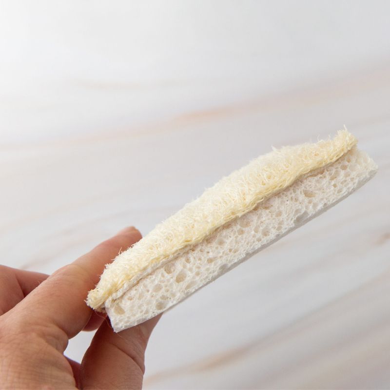 Green Essentials - cellulose and loofah soft sponge scrubber - set of 3 - hand holding one shown from the side. 