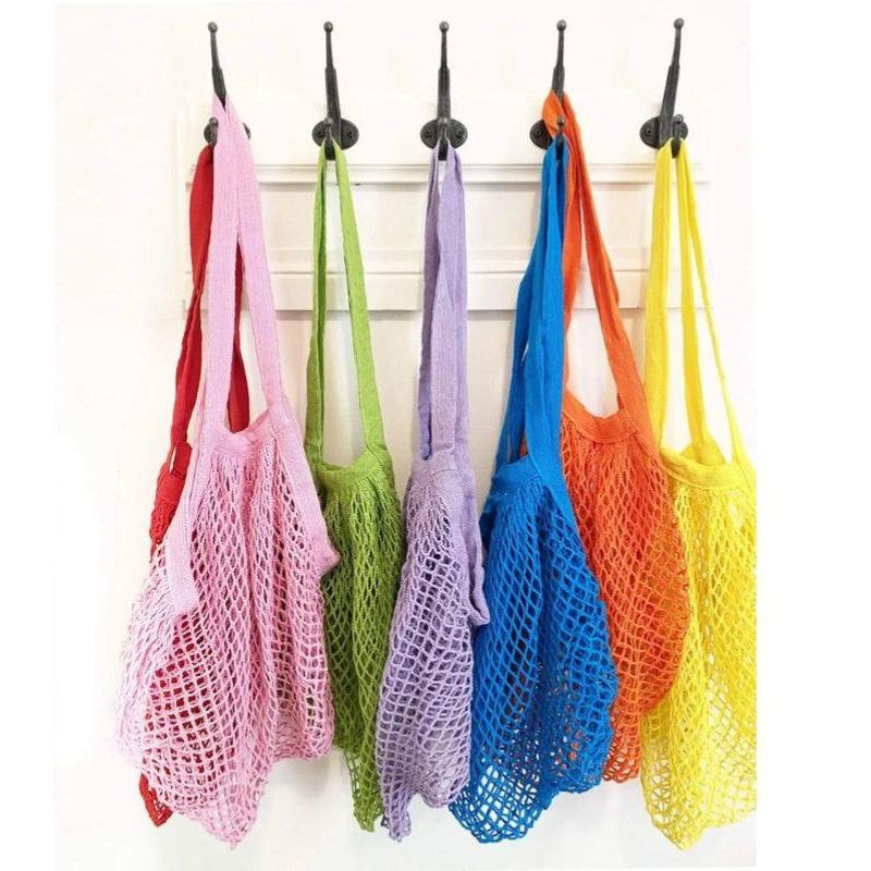 Green Essentials large mesh shopping bag - mix of colours hanging.