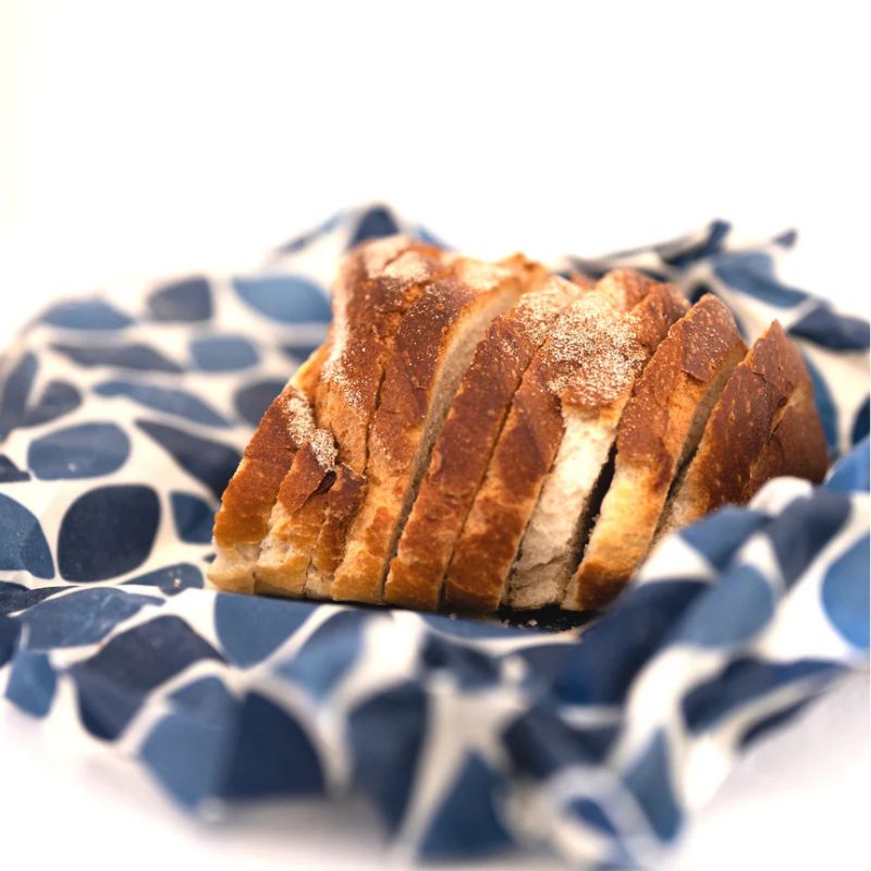 Honeybee Wrap - beeswax wrap - shown with cut bread on top. 