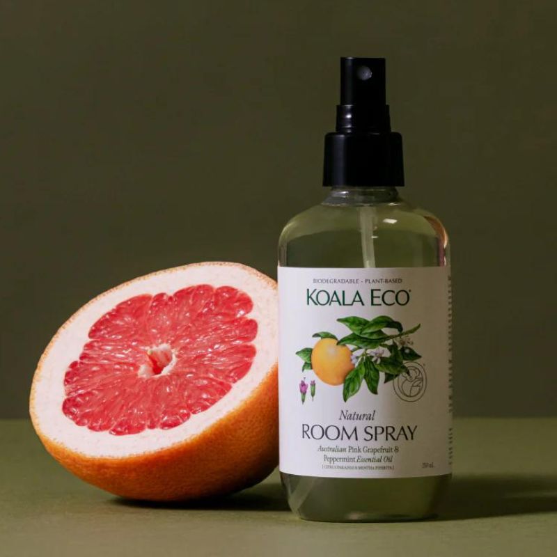 Koala Eco - Room spray with pink grapefruit and peppermint - with half cut grapefruit in front of bottle.