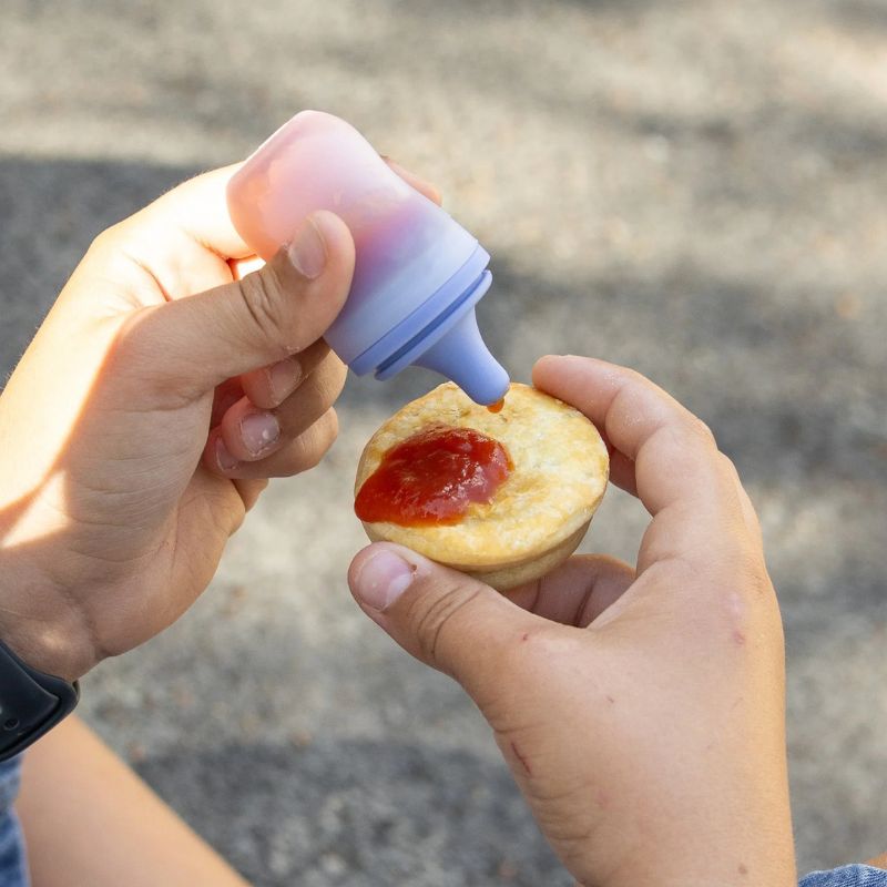 MontiiCo silicone sauce bottle - set of 2 - photo showing sauce being put on a pie.