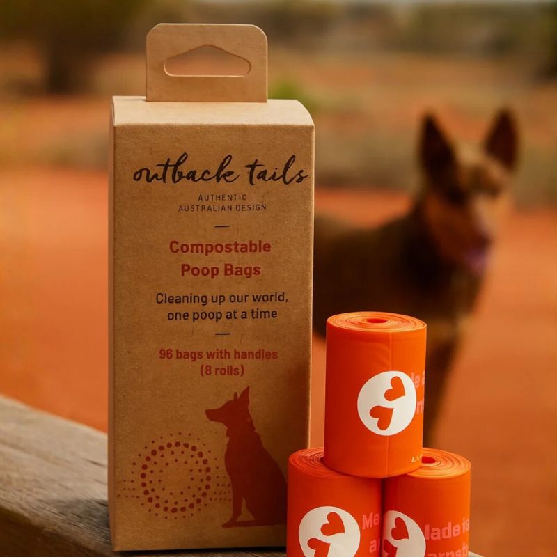 Outback Tails compostable dog poop bag - 3 rolls next to box and a dog. 