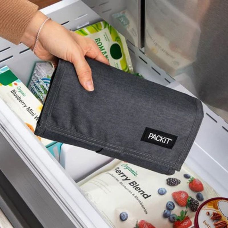 PackIt freezable insulated lunch cooler bag - folded and being put in a freezer.
