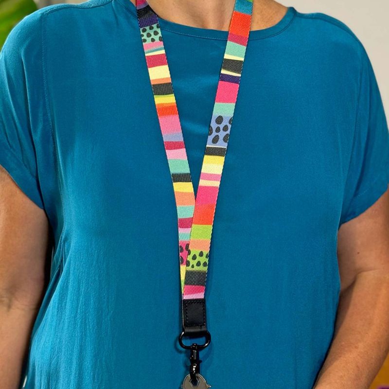 Ruby Olive - Long lanyard - Rainbow Stripe - with keys hanging on woman. 