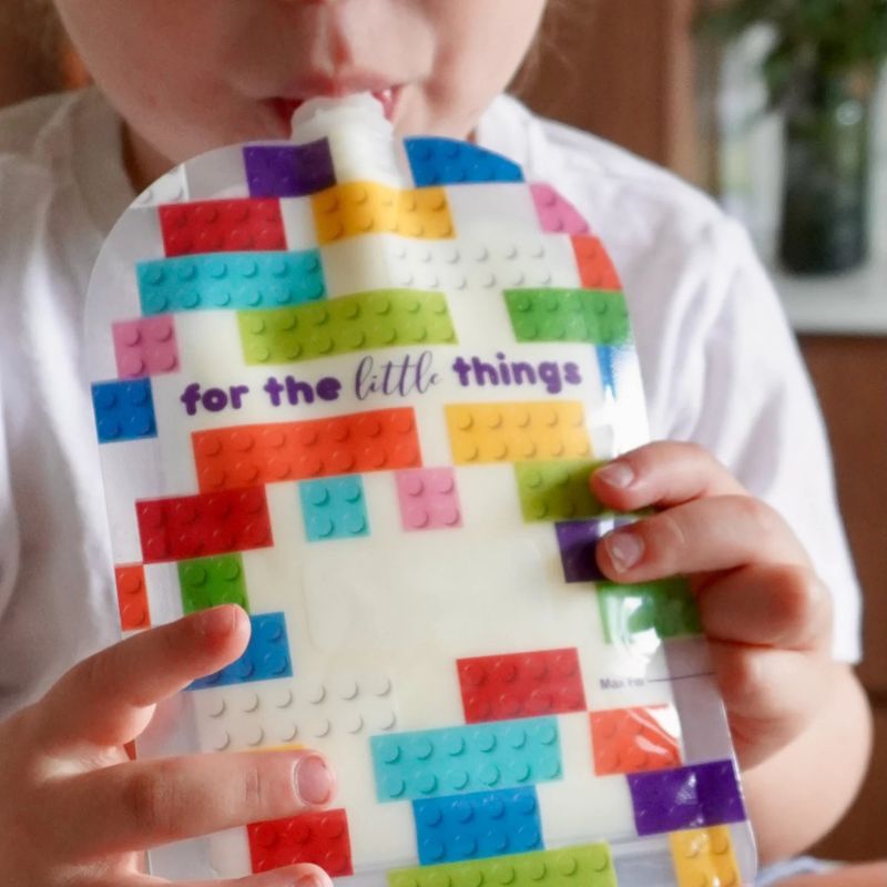 Sinchies reusable food pouch- child holding and eating from a pouch.