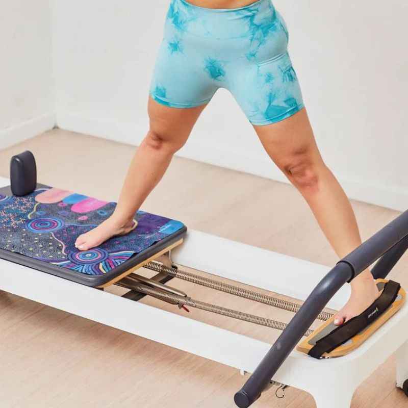 Wild Mingo reformer exercise mat - woman standing on machine.