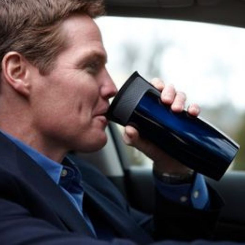 Showing man in car drinking from a Contigo Westloop coffee cup.