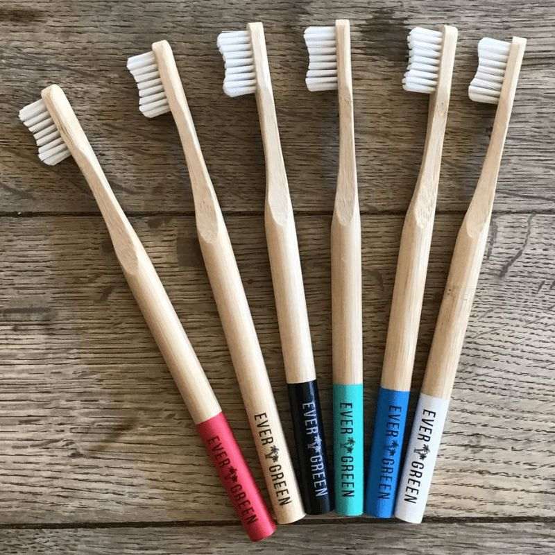 Evergreen bamboo toothbrush - photo with all 6 colours on a table. 