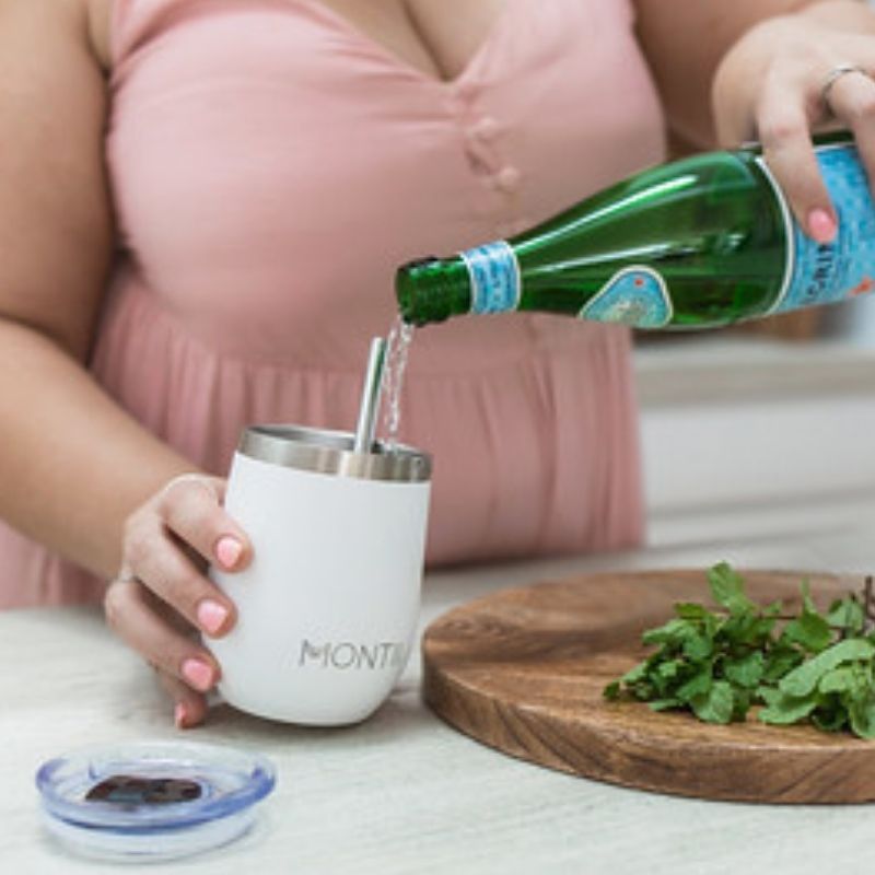 MontiiCo insulated wine sippy tumblers  with lids and a straw - a woman pouring water in a white tumbler.
