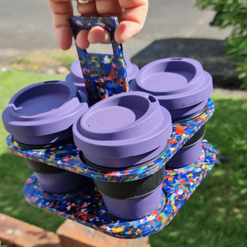 Reusable Takeaway coffee cup tray carrier holder made from recycled plastic lids - 4 cups - shown hand holding tray with 4 cups in.