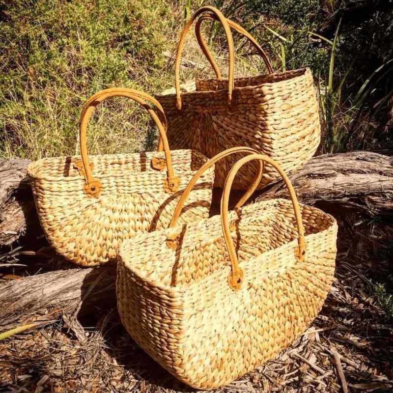 Water Hyacinth rectangle basket with suede handle i natural - 3 different sizes shown outside.